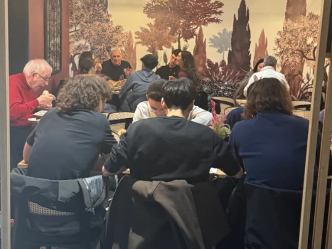 La salle pleine de La Toscana devant la fresque toscane